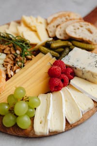 Close-up of a gourmet cheese board featuring various cheeses, fruits, and nuts.